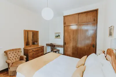 a bedroom with a bed and a wooden cabinet at Casa Branca Apartments by Wanderlust Madeira, vacation rentals in Funchal