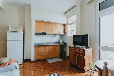 a kitchen with wooden cabinets and a tv in it at Casa Branca Apartments by Wanderlust Madeira, vacation rentals in Funchal