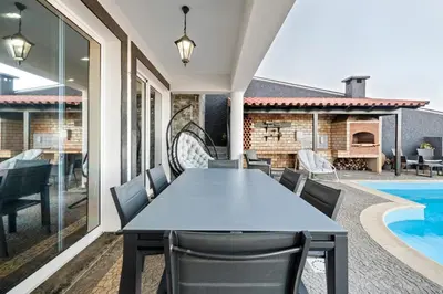 a dining room with a table and chairs and a swimming pool at São Lourenço Guest House in Caniçal