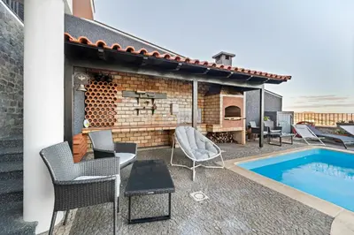 a patio with a fireplace and a swimming pool at São Lourenço Guest House in Caniçal
