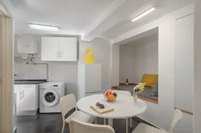 a kitchen and dining room with a white table and chairs at OurMadeira - Vintage Garden Apartment in Funchal