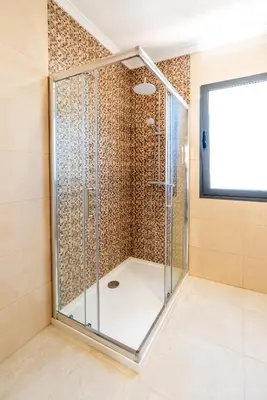 a shower in a bathroom with a glass door at Goncalves House - AC and private parking in Calheta