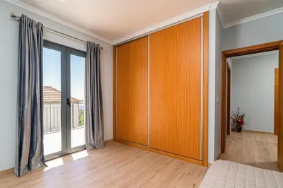 a bedroom with a large wooden closet with sliding doors at Goncalves House - AC and private parking in Calheta