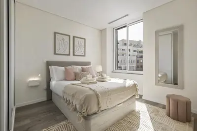 a white bedroom with a bed and a window at Carmo Charm Apartment by Homie in Funchal