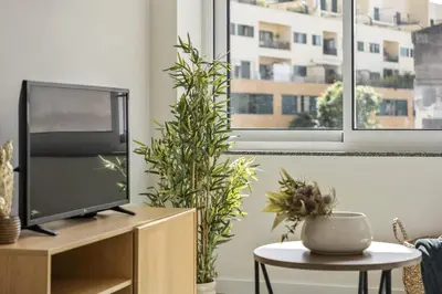 a living room with a tv on a wooden cabinet at Carmo Charm Apartment by Homie in Funchal