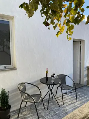a patio with two chairs and a table with a bottle of wine at Casa Beleza in Funchal