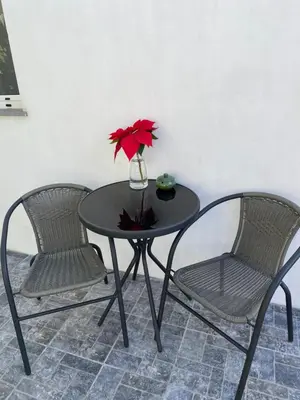 a table with two chairs and a vase with a red flower at Casa Beleza in Funchal