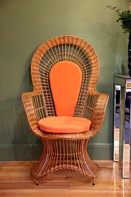 a wicker chair with an orange seat on a wooden floor at 29 Madeira Hostel in Funchal