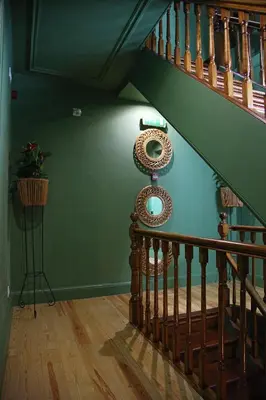 a staircase in a house with a green wall at 29 Madeira Hostel in Funchal