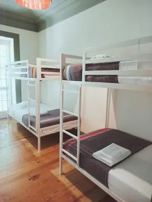 a room with three bunk beds in a room at 29 Madeira Hostel in Funchal