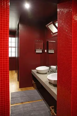 a bathroom with two sinks and a red wall at 29 Madeira Hostel in Funchal
