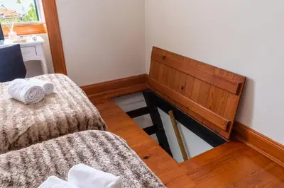 a small room with a bed and a wooden bench at Sleep Among the Bananas! Rustic Cottage with Trails at Your Doorstep in Ponta do Sol
