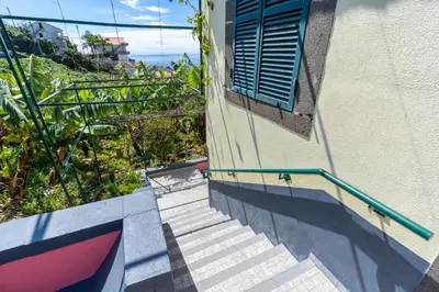 a set of stairs leading up to a building with a window at Sleep Among the Bananas! Rustic Cottage with Trails at Your Doorstep in Ponta do Sol