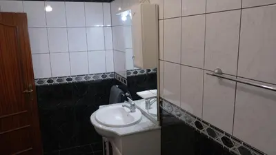 a bathroom with a sink and a toilet and a mirror at Quinta do Carmo house with View in Calheta