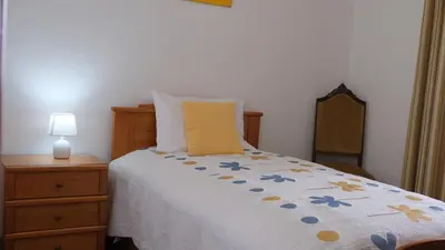 a bedroom with a bed and a nightstand and a bed sidx sidx at Quinta do Carmo house with View in Calheta