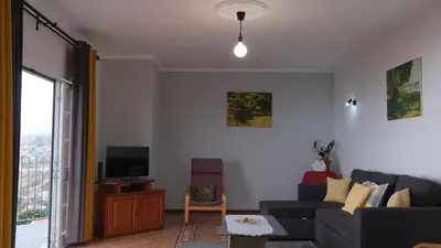 a living room with a couch and a tv at Quinta do Carmo house with View in Calheta