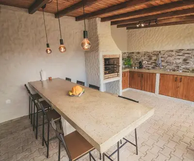 a kitchen with a large wooden table with chairs at Slowing Villas - Villa Âncora in Porto Santo