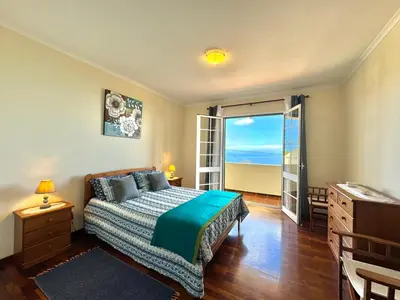 a bedroom with a bed and a view of the ocean at Moradia Abreu in Santa Cruz