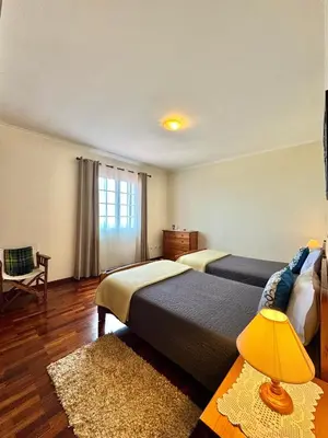 a hotel room with two beds and a window at Moradia Abreu in Santa Cruz