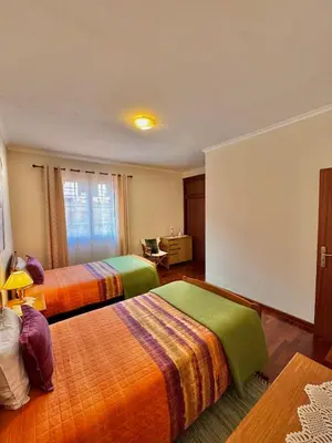 a hotel room with two beds and a window at Moradia Abreu in Santa Cruz