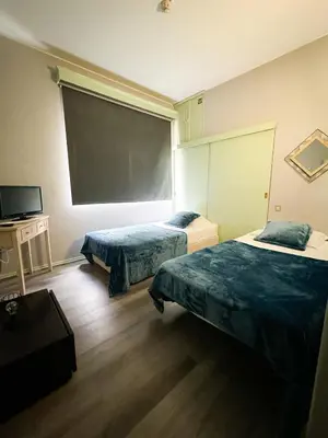 a room with two beds and a large screen at Hostel Monaco in Funchal