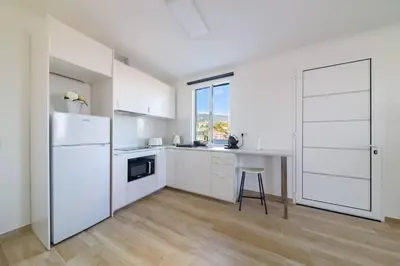 a white kitchen with a table and a refrigerator at Casa das Virtudes by Mth in Funchal