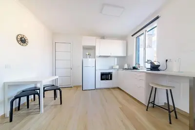 a kitchen with white cabinets and a table and chairs at Casa das Virtudes by Mth in Funchal