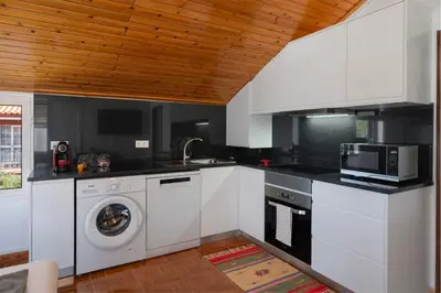 a kitchen with a washing machine and a microwave at OurMadeira - Prazeres Paradise in Prazeres