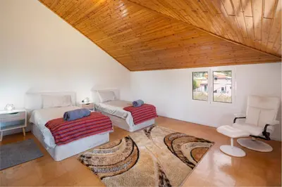 a bedroom with two beds and a chair in it at OurMadeira - Prazeres Paradise in Prazeres