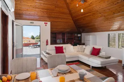 a living room with a white couch and red pillows at OurMadeira - Prazeres Paradise in Prazeres