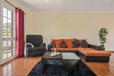 a living room with a couch and a chair at Palm Tree House by Homie in Ponta Delgada