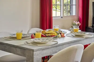 a table with a breakfast of food and orange juice at Palm Tree House by Homie in Ponta Delgada