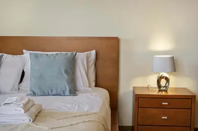 a bedroom with a bed and a nightstand with a clock at Palm Tree House by Homie in Ponta Delgada