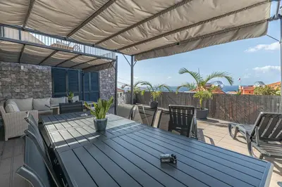 a patio with a table and chairs on a deck at Flowers island house 5 in Funchal