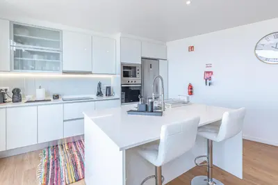 a white kitchen with white cabinets and a sink at Flowers island house 5 in Funchal