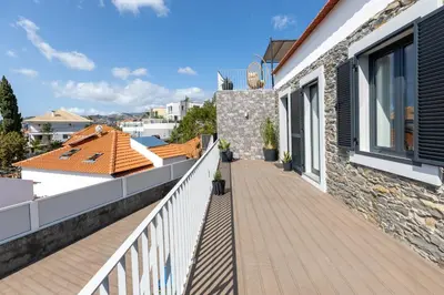 a balcony of a house with a white railing at Flowers island house 5 in Funchal