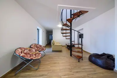 a living room with a spiral staircase and chairs at Casa Cabral by MTH in Ponta do Sol