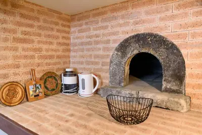 a kitchen with a brick wall with a stone oven at Casa Cabral by MTH in Ponta do Sol