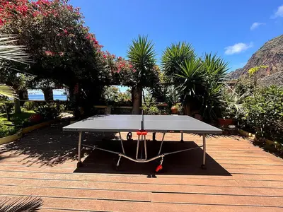 a ping pong table sitting on top of a wooden deck at Suite Bela Vigia 3 in Jardim do Mar