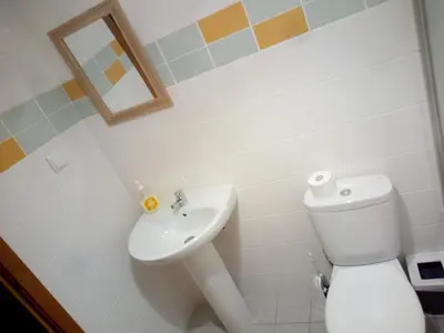 a bathroom with a toilet and a sink at Costa Lodges, Funchal or Santa Cruz Madeira, shared room in Santa Cruz