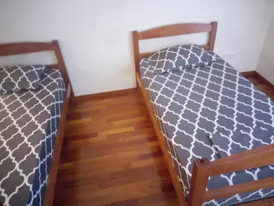 two beds sitting next to each other in a room at Costa Lodges, Funchal or Santa Cruz Madeira, shared room in Santa Cruz