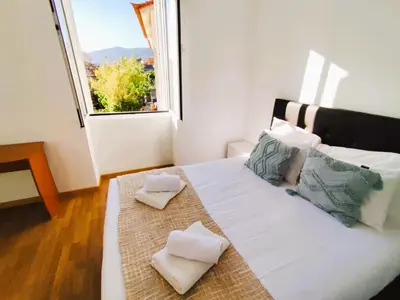 a small child laying on a bed in a room with a window at Sea House in Funchal