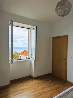 an empty room with a large window and a door at Sea House in Funchal