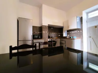 a large kitchen with a table and chairs in it at Sea House in Funchal