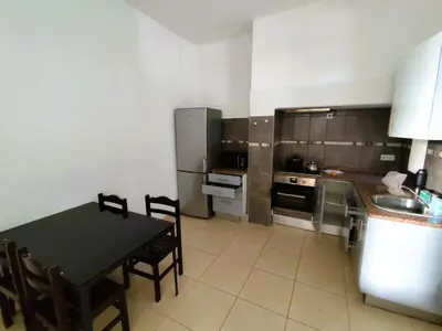 a kitchen with a table and a kitchen with a refrigerator at Sea House in Funchal