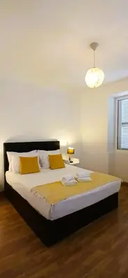 a bedroom with a large bed with yellow pillows at Sea House in Funchal