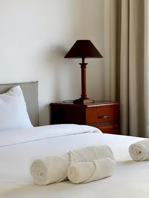 a bedroom with two beds with white sheets and a lamp at K&K Apartments in Machico