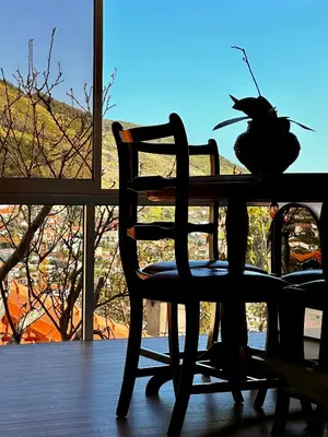 a table with a chair and a vase on it at K&K Apartments in Machico