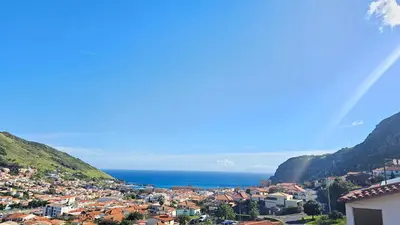 a view of a town with mountains and the ocean at K&K Apartments in Machico