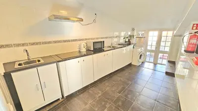 a kitchen with white cabinets and a tile floor at K&K Apartments in Machico